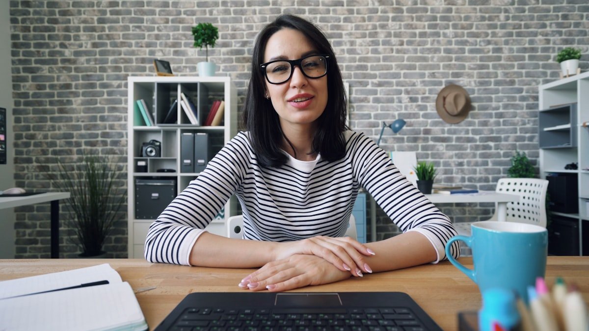 A client on a video consulting call, laptop open on the desk